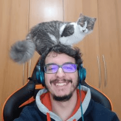 Um homem sorridente com um gato em cima da cabeça